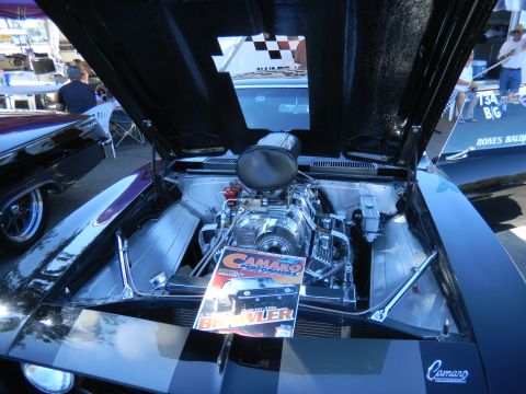1997 Ford Ranger - Car engine bay with a prominent supercharger and a Camaro magazine on display.