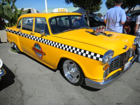 1997 Ford Ranger - A modified yellow taxi with a prominent hood scoop and checkerboard side stripe is on display.