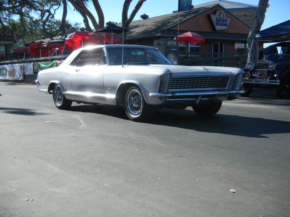 Silver 1965 Buick Riviera parked on street, another car visible behind it