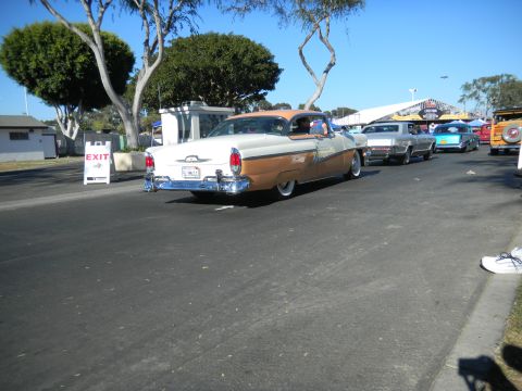 1997 Ford Ranger - A classic two-tone Mercury sedan is seen from the rear at a car show with other vehicles in the background.