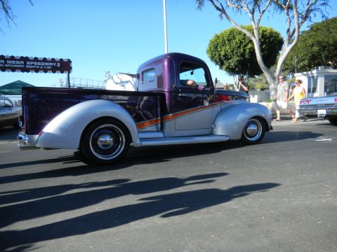 1997 Ford Ranger - A customized vintage pickup truck is parked at an outdoor event, with other vehicles and people nearby.