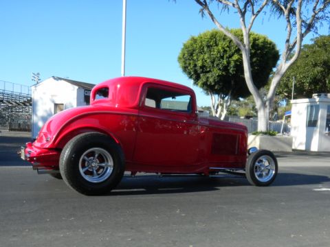 1997 Ford Ranger - A classic red hot rod coupe is parked outdoors on a sunny day.