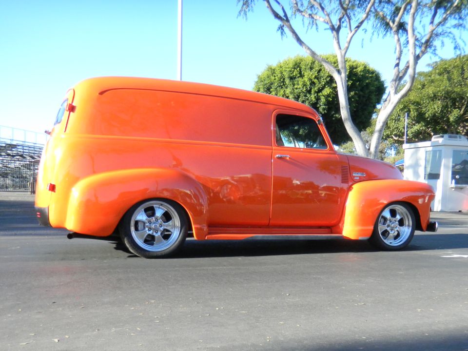 Orange panel van with custom wheels, seen from the side