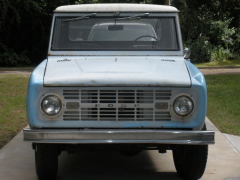 1966 Ford Bronco - This classic SUV features a prominent horizontal grille with the 'FORD' lettering clearly visible.
