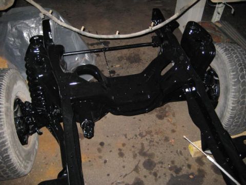 1988 Ford Bronco - Close-up of a freshly painted vehicle frame and suspension system, with one tire visible.