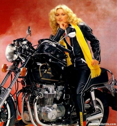1999 Ford Crown Victoria - A woman in leather poses on a black motorcycle with a yellow scarf.
