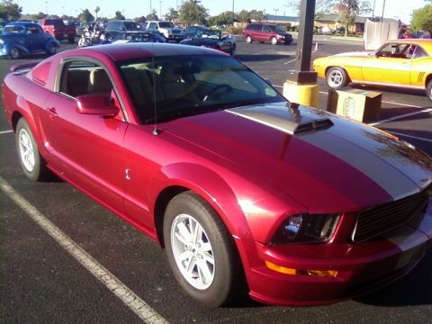 2000 Harley-Davidson FXDWGI Wide Glide - Red Ford Mustang coupe with silver racing stripes is parked in a lot with other vehicles.
