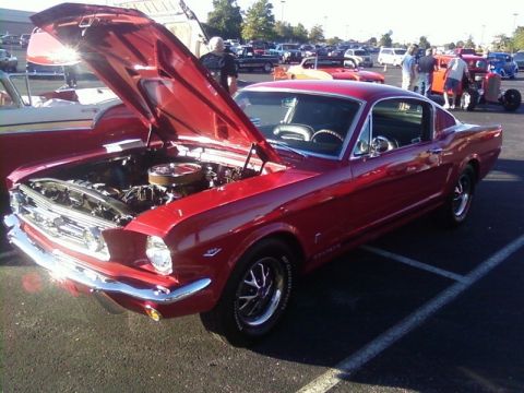 2000 Harley-Davidson FXDWGI Wide Glide - A classic red 1965 Ford Mustang Fastback is displayed with its hood open at an outdoor car show.