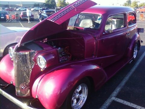 2000 Harley-Davidson FXDWGI Wide Glide - A vintage purple sedan with its hood open at a car show, revealing a white interior with a Chevrolet emblem.