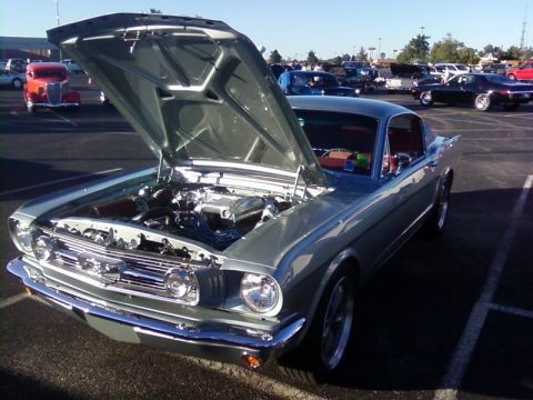 2000 Harley-Davidson FXDWGI Wide Glide - Classic 1965 Ford Mustang coupe at a car show, hood raised to display the engine.