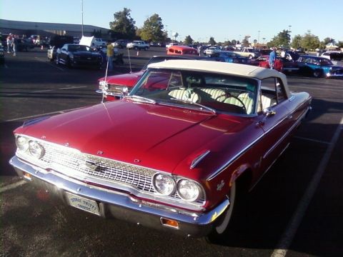 2000 Harley-Davidson FXDWGI Wide Glide - A classic red Ford Galaxie convertible is parked in a lot with other vehicles under a clear sky.