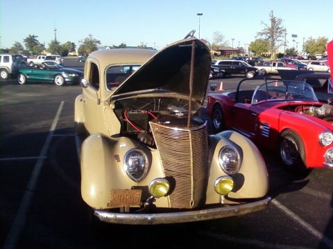 2000 Harley-Davidson FXDWGI Wide Glide - A tan 1939 Ford coupe is parked at a car show with its hood open, next to a red convertible.
