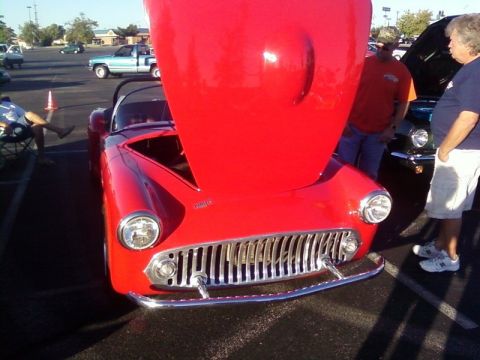 2000 Harley-Davidson FXDWGI Wide Glide - Front view of a red convertible with its hood raised, parked at an outdoor event.