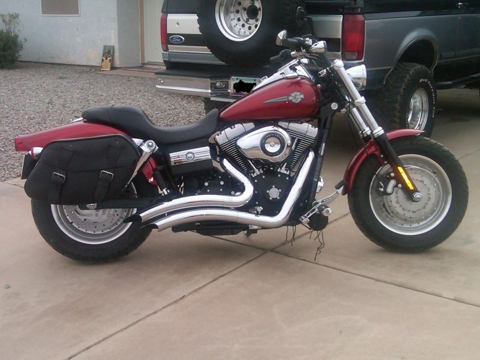 Red Harley-Davidson motorcycle parked in front of a Ford pickup truck
