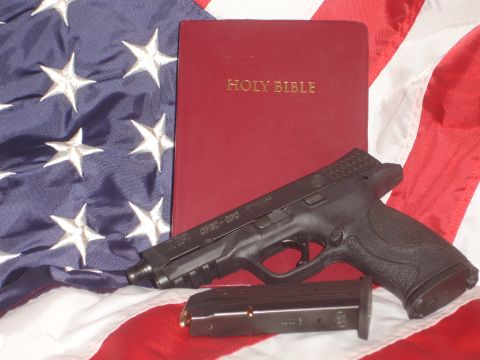 1982 Ford Bronco - A black pistol and a Holy Bible are placed on an American flag, symbolizing faith and freedom.