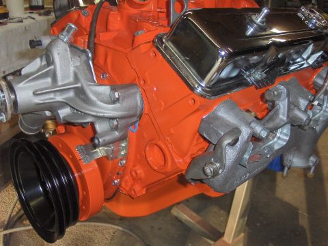 1970 Chevrolet Camaro - Close-up view of an orange engine block with various components attached.