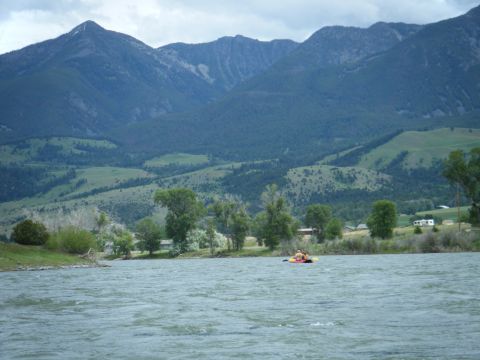 1981 Ford E350 - A kayak floats on a river with a mountainous landscape in the background.