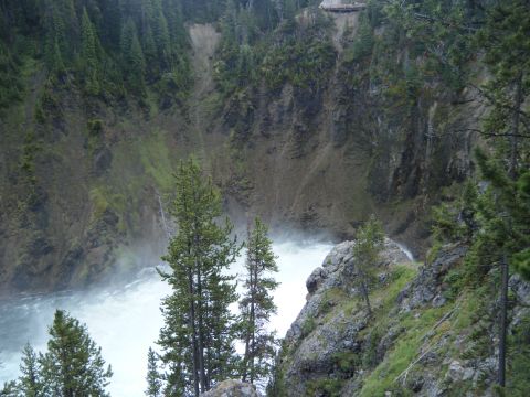 1981 Ford E350 - A scenic view of a waterfall and surrounding forest, with a small structure visible on the cliff edge.