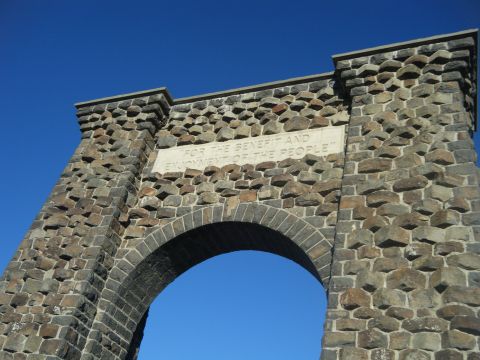 1981 Ford E350 - A stone archway with an inscription is seen against a clear blue sky.