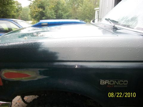 1993 Ford Bronco - Side view of a 1993 Ford Bronco, an aftermarket hood scoop and visible body repair.