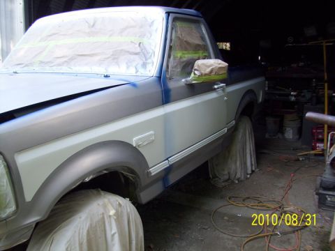 1993 Ford Bronco - A 1993 Ford Bronco is shown in a garage, covered in protective materials as it undergoes a paint job.