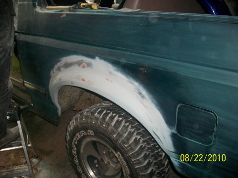 1993 Ford Bronco - Body filler is being applied to the rear fender of a 1993 Ford Bronco during restoration.