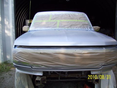 1993 Ford Bronco - A 1993 Ford Bronco is seen from the front, covered in masking tape and paper as it is prepared for a paint job.