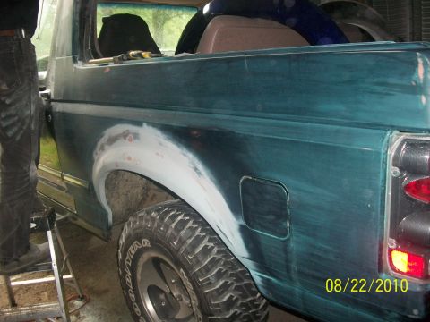 1993 Ford Bronco - Ford Bronco rear quarter panel being prepped for paint, showing body filler and sanding.