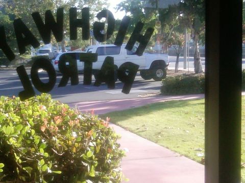 1986 Ford Bronco - A white SUV is visible through a window with "HIGHWAY PATROL 49" lettering superimposed.