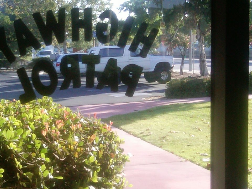 White SUV seen through window with "HIGHWAY PATROL 49" text