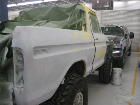 1978 Ford Bronco - A Ford Bronco is being prepped for paint, with a tarp covering the interior and a second vehicle parked behind it.