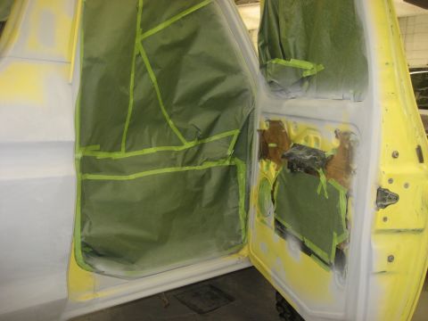 1978 Ford Bronco - The interior door panels of a vehicle are covered in masking paper and tape, preparing for paintwork.