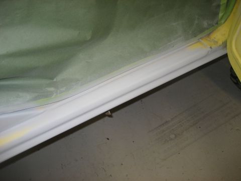 1978 Ford Bronco - A car door sill is covered in masking paper and tape, ready for bodywork or painting.