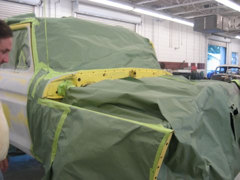 1978 Ford Bronco - Vehicle being prepped for paint, covered in green tarp. Another vehicle is parked in the background.