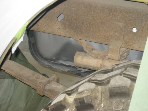 1978 Ford Bronco - This photo shows the rear suspension components and a tire of a vehicle, with a watermark from Supermotors.net.