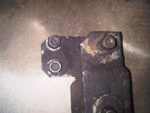 1986 Ford Bronco - This is a close-up view of a rusted metal bracket with visible bolts.