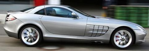 2000 Mercury Grand Marquis - A silver sports car is captured in motion, showing its distinctive side vents and wheels.