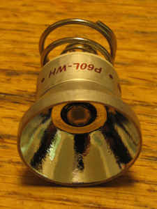 1984 Ford Bronco - Close-up of a flashlight reflector and bulb assembly with visible part numbers.