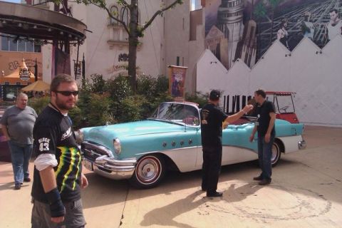 1991 Ford Crown Victoria - A light blue and white 1954 Buick convertible is parked outdoors with people around it.