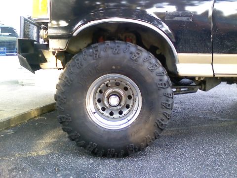 1990 Ford Bronco - Close-up of the front wheel and fender of a 1990 Ford Bronco with off-road tires.