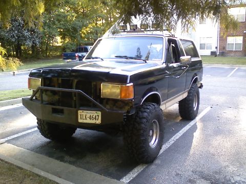 1990 Ford Bronco - This modified Ford Bronco features a custom bumper and large tires, suggesting a model year earlier than 1990.