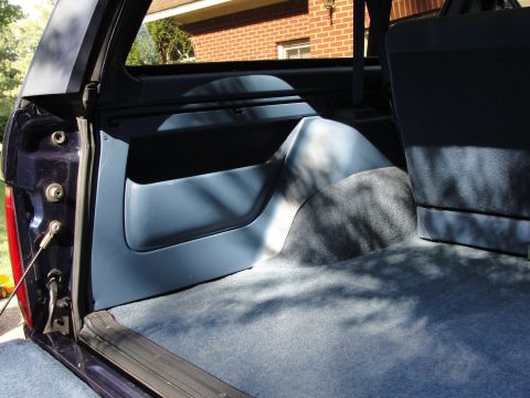 1967 Ford Mustang - The interior of a Ford Bronco is shown, blue plastic trim and carpeted surfaces.