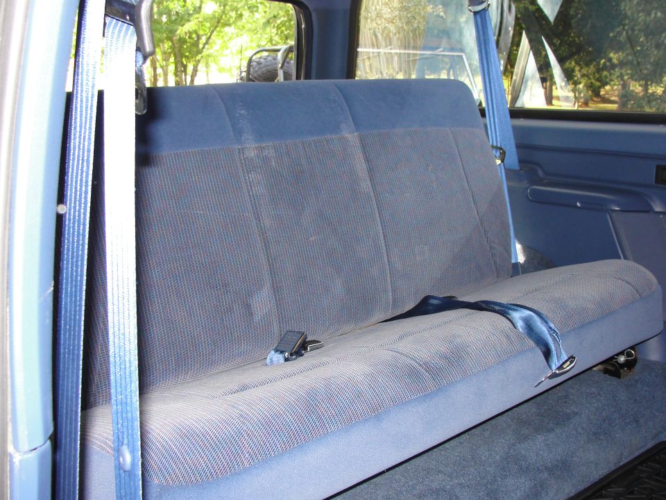 Back seat and seatbelts inside a vehicle. A watermark says www.supermotors.net