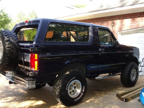 1967 Ford Mustang - This dark blue Ford Bronco is shown from the rear, a spare tire mounted on the tailgate.