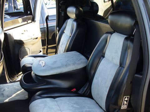 2007 Ford Mustang - The interior of a vehicle shows two-tone bucket seats and a prominent center console with a logo.