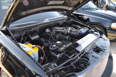 2007 Ford Mustang - Engine bay of a black truck, with another truck visible in the background.