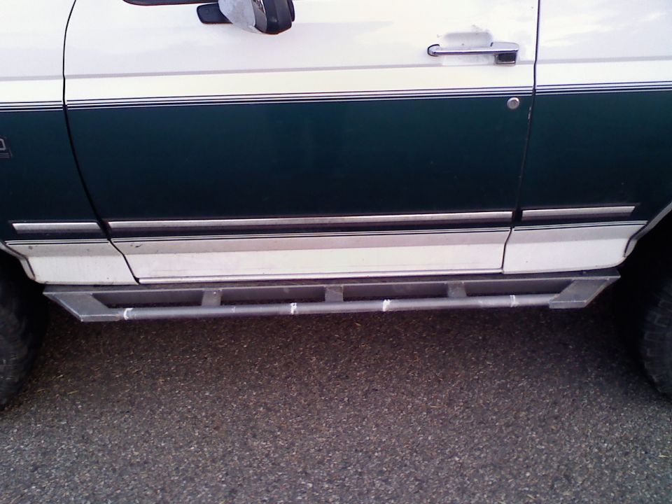 White and dark green 1996 Ford Bronco side view with metal step sliders