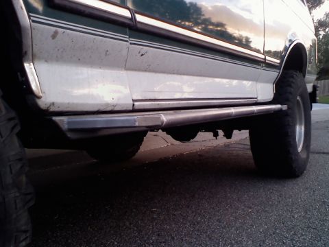1996 Ford Bronco - This 1996 Ford Bronco features aftermarket sliders and large tires, visible from a side profile.
