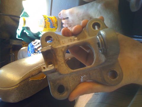 1992 Ford Bronco - A metal bracket with a date stamp is held in a hand, with a Yoohoo bottle in the background.