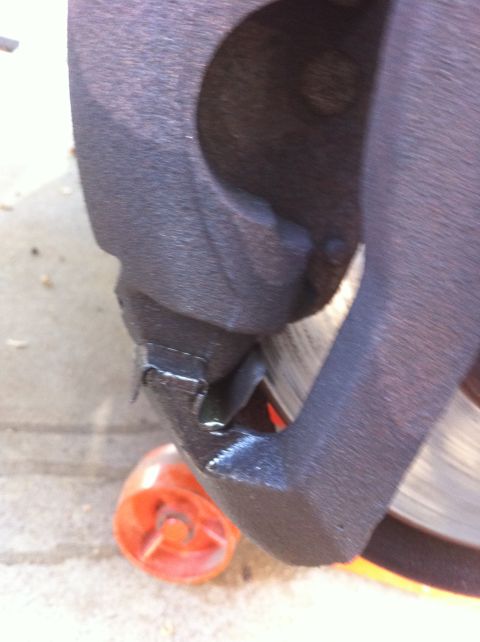 1997 Ford F-350 - Brake caliper and rotor detail, with an orange chock underneath.
